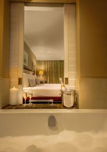 东伦敦Hemingways Hotel的浴室设有床和带镜子的盥洗盆