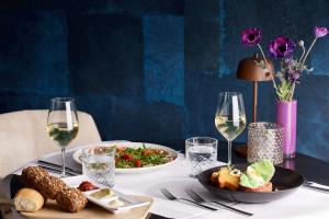 蒂尔蒂尔凡德瓦克酒店的一张桌子,上面放着两盘食物和酒杯