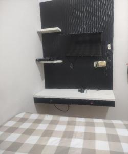 贝克西SPOT ON 93853 Budi Residence 2的一间卧室设有一张黑色的办公桌和一个 ⁇ 格地板。