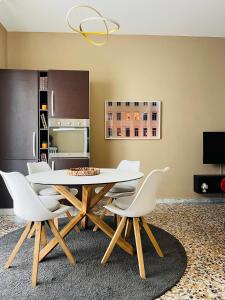 博洛尼亚Bononia Host - Beverara的一间带桌子和白色椅子的用餐室