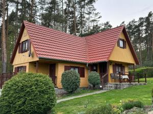 PřešticeChata u lesa的红色屋顶的黄色小房子