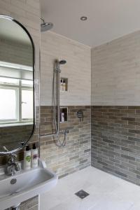 纽伯里卡尔纳翁阿姆斯酒店的带淋浴、水槽和镜子的浴室