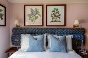 纽伯里卡尔纳翁阿姆斯酒店的一间卧室配有一张带蓝色和白色枕头的床