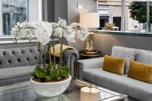 格拉纳达Hotel Boutique Las Almenas的客厅配有沙发和白色花瓶