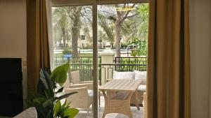 拉斯阿尔卡麦Luxury villa 4 bedroom with pool access的阳台的滑动玻璃门,配有桌椅