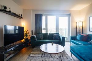 伦敦Charming 1-Bed Apartment in London的客厅配有蓝色的沙发和电视