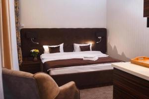 基希讷乌Time Hotel&SPA的一间卧室配有一张大床和棕色床头板