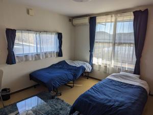 郡山Guest House Koriyama的带窗户的客房内的两张床