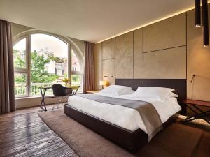 阿姆斯特丹Conservatorium Hotel的一间卧室设有一张大床和大窗户