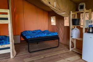 伊皮Safaritent op groen en kindvriendelijk park op de Veluwe的帐篷内的一个床位房间