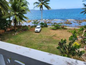 HinunanganTwin Island Beach House的停在海边草地上的白色汽车