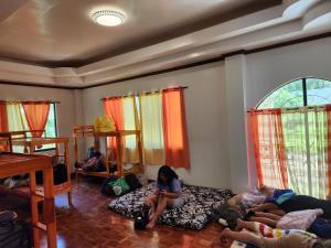 HinunanganTwin Island Beach House的一群人坐在房间里的床边