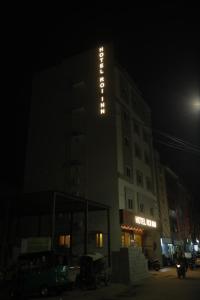 蒂鲁帕蒂HOTEL ROI INN的夜间标有标志的酒店大楼