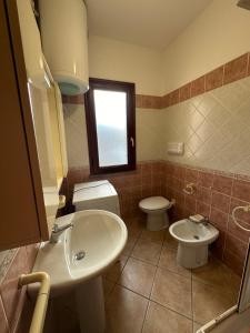 波萨达Grazioso appartamento a Posada的一间带水槽和卫生间的浴室以及窗户。