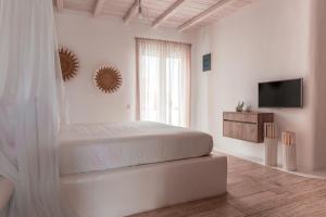 埃利亚海滩Senses Luxury Suites & Villas的一间白色卧室,配有床和电视
