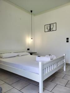基尼拉Aura Guesthouse的白色的卧室配有白色的床和一张桌子