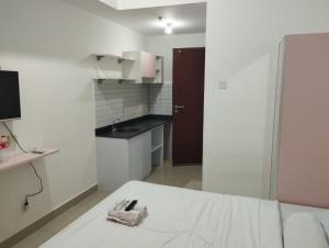 贝克西Capital O 93854 Apartemen Sayana By Sentra Jaya的一间白色的小厨房,在房间内配有一张床