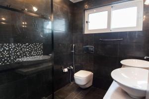 雅典Riviera Retreat 3 Bedroom Voula Luxury Haven Apt的浴室配有2个盥洗盆、卫生间和淋浴。