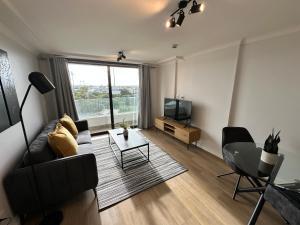 开普敦Newlands Peak Apartments的带沙发、电视和桌子的客厅
