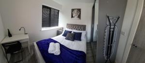 拉夫堡SAV Apartments Nottingham Road Loughborough - 1 Bed Flat的一间卧室配有一张带蓝色床单和枕头的床。