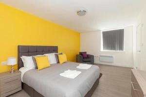 拉夫堡SAV Apartments Clarence Street-Loughborough的一间卧室设有一张黄色墙壁的大床