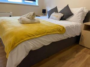 沃特福德SAV 1 Bedroom Flat near Watford Town Centre的一张大床,上面有黄色的毯子