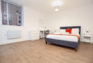 莱斯特SAV Apartments Regent Leicester的一间卧室配有一张床、一张书桌和一个窗户。