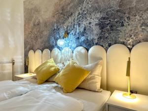 维也纳维也纳艺术酒店的一间卧室配有白色床和黄色枕头