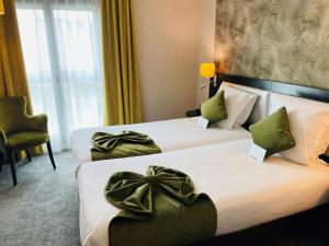 巴黎贝斯维斯特阿尔格鲁内申酒店的酒店客房,设有两张带绿 ⁇ 的床