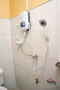 LiraKica Apartment with Airconditioned bedrooms in Lira, Uganda的带淋浴的浴室,墙上配有手持烘干机