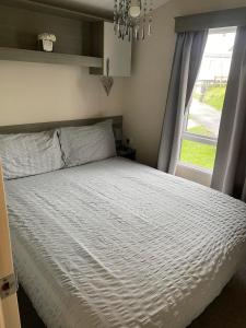 韦茅斯Littlesea Haven fleetview的卧室配有白色的床和窗户。