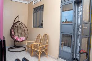 LiraKica Apartment with Airconditioned bedrooms in Lira, Uganda的门廊上摆着一对椅子和秋千