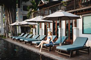 清迈Buri Sriping Riverside Resort & Spa - SHA Extra Plus的坐在游泳池旁椅子上的女人