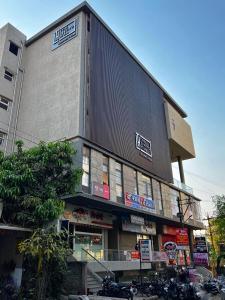 戈尔哈布尔The Living Hub Hotel, Kolhapur- Walkable From Central Bus Station的一座大型建筑,前面停有摩托车