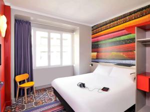 里尔里尔中心大广场宜必思尚品酒店 的酒店客房,配有一张带耳机的床