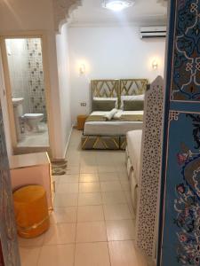 梅克内斯里亚德马拉克酒店的一间卧室设有一张床和一间浴室。