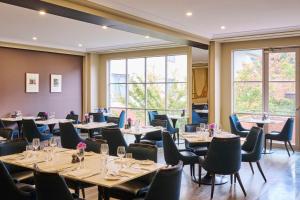 堪培拉堪培拉凯悦酒店 - 柏悦酒店的用餐室设有桌椅和窗户。