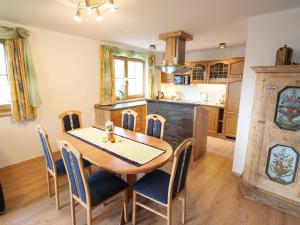 塔克森巴赫Cosy holiday flat in a farmhouse的厨房以及带木桌和椅子的用餐室。