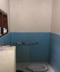 万隆OYO 93846 Gerlong Homestay的一间带卫生间的浴室和蓝色瓷砖墙