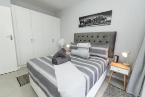 GqeberhaThe Cozy Traveller的卧室配有一张带灰色和白色床单的床。