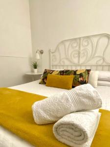 巴勒莫Alvorada Rooms的卧室配有白色床和黄色毯子