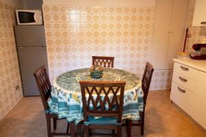 圣玛格丽塔-利古雷Posa的厨房配有带四把椅子的桌子和冰箱。