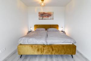 PrievozCozy apartment near city centrum and Bratislava airport的一间白色客房内配有金色床的卧室