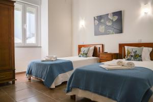 雷根古什-迪蒙萨拉什Casa do Castelo的一间卧室配有两张带毛巾的床