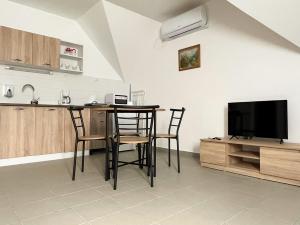 佐洛卡罗斯Thermal Camping Zalakaros的厨房配有桌椅和电视。