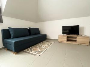 佐洛卡罗斯Thermal Camping Zalakaros的客厅配有蓝色的沙发和平面电视。
