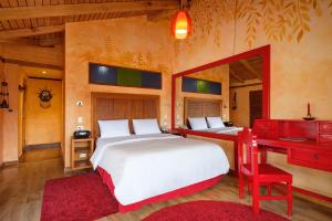 巴尼奥斯Luna Volcán, Adventure SPA的一间卧室配有两张床和一张红色的书桌