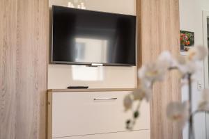 林茨林茨市公寓的白色梳妆台上方的平面电视