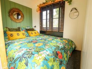 雷特福德Portland的一间卧室配有一张带五颜六色棉被的床