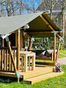霍尔沃德Camping Zee van Tijd Holwerd的一个带桌子的木制凉亭
